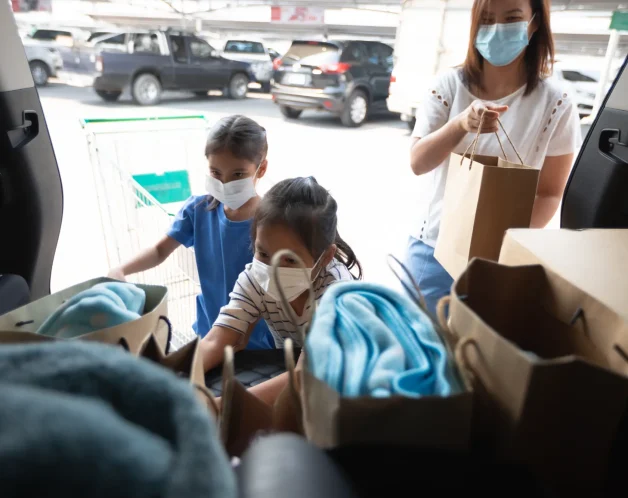 mother-daughter-wearing-mask-putting-grocery-car